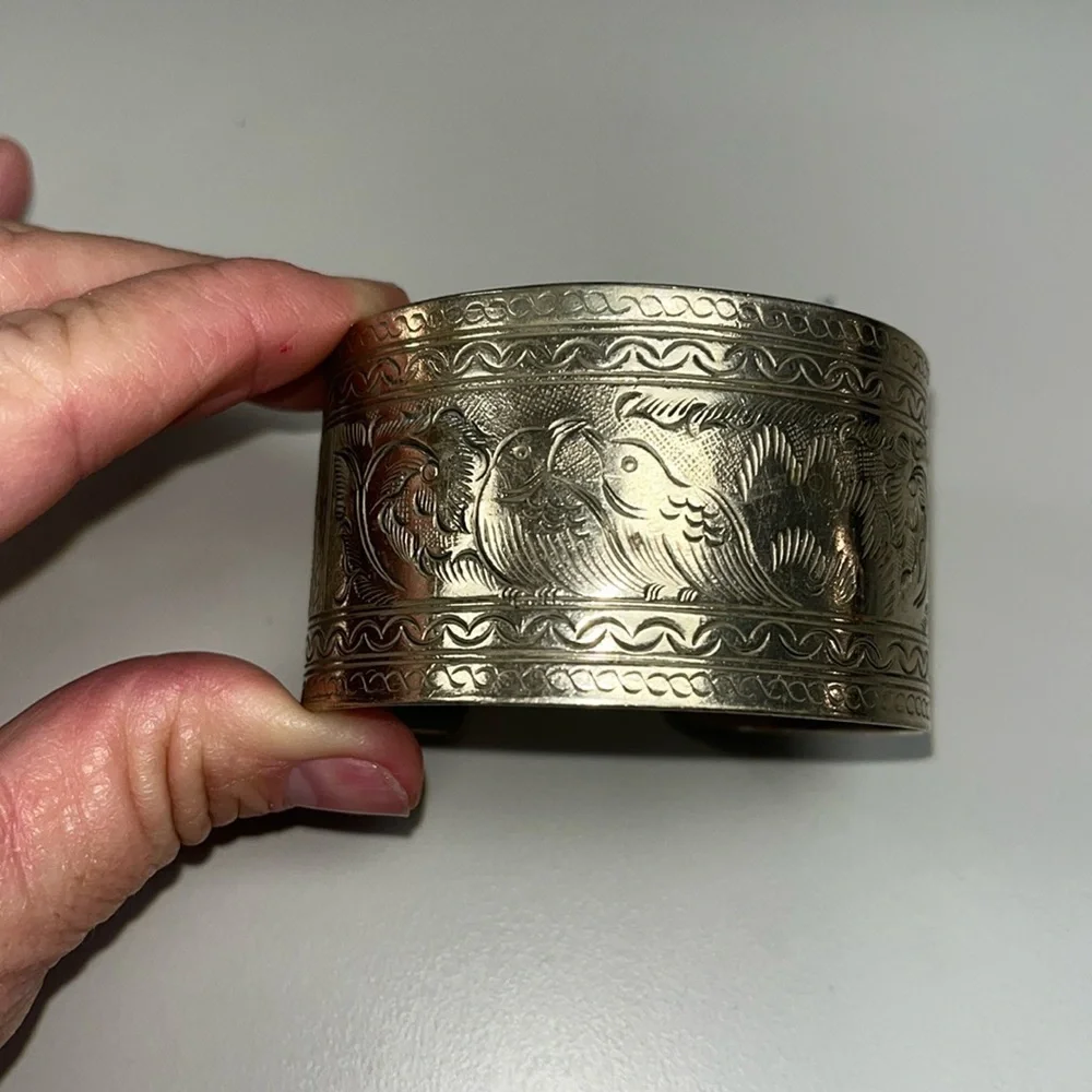 Silver toned metal etched cuff with birds and other unique details